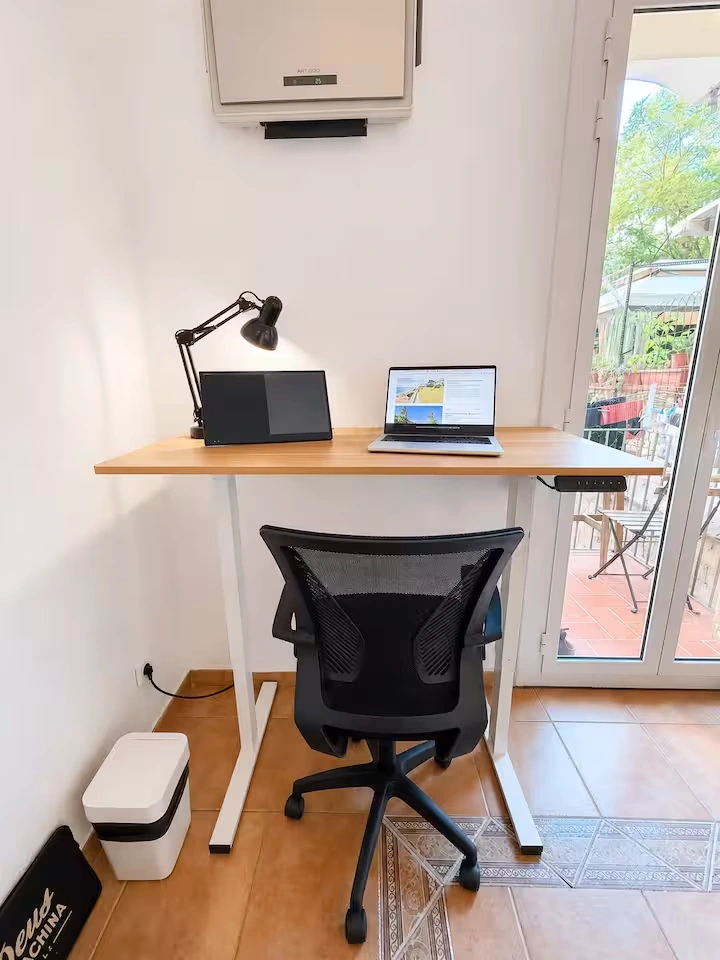 Main bedroom: sit-stand desk beside the balcony